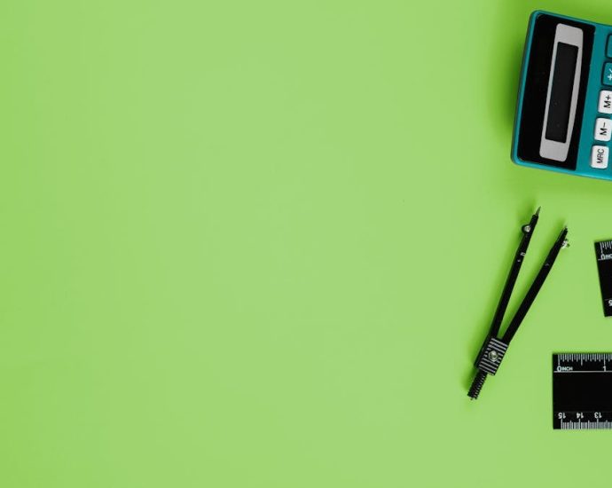 Calculator and drawing tools on a vibrant green background with ample copy space.